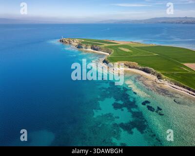 Ein atemberaubender Blick aus der Vogelperspektive auf das Beans Burn Lighthouse in Canakkale mit kristallklarem türkisfarbenem Wasser, üppigen grünen Feldern und einer unberührten Küste Stockfoto