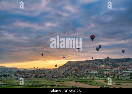 Atemberaubende Aussicht auf Heißluftballons, die anmutig über die einzigartige Landschaft von Kappadokien, Türkei, schweben, bei Sonnenaufgang und zeigen die berühmte Messe der Region Stockfoto