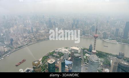 Aus der Vogelperspektive von Shanghai, China, mit Blick auf das geschäftige Stadtbild mit hoch aufragenden Wolkenkratzern und dem ikonischen Oriental Pearl Tower am Huangpu River, Stockfoto