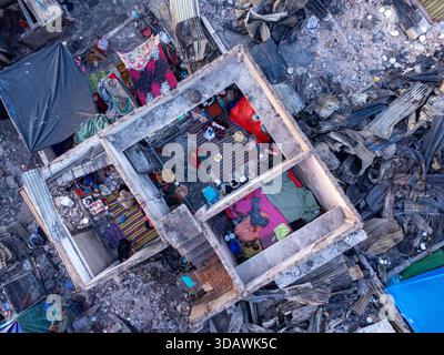 Dhaka, Bangladesch - 28. November 2025: Aus der Vogelperspektive auf die Skelettreste einer Wohnung inmitten einer Landschaft, die von Feuer vernarbt ist Stockfoto