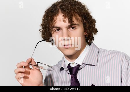 Der Teenager zeigt einen trendigen Look, hält die Brille und zeigt gleichzeitig einen einzigartigen Sinn für Mode. Stockfoto