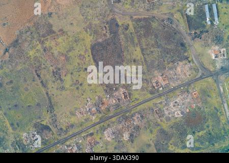 Blick von oben auf ein vollständig zerstörtes Wohngebiet mit zerschlissenen Solarstromanlagen zwischen Hausruinen. Die ausweichenden Auswirkungen der modernen Kriegsführung auf die zivile Infrastruktur und die grünen Energiesysteme in der Konfliktzone Osteuropas Stockfoto