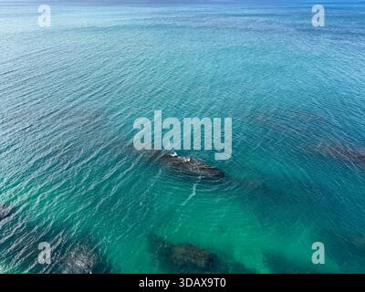 Blick aus der Vogelperspektive auf das wunderschöne Meer und die Unterwasserfelsen Stockfoto