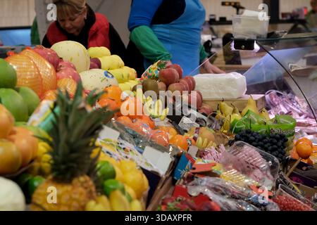 Shopper erkunden eine bunte Auswahl an Obst und Gemüse auf einem lebhaften Markt. Kiew, Ukraine. Dezember 2025. Stockfoto