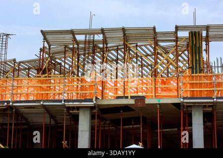 Arbeiter bauen Holzgerüste für neue Gebäude auf, während die Ausrüstung sichtbar ist Stockfoto
