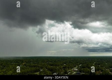 Regenschauer über der ländlichen Stadt Floridas in der feuchten Sommersaison. Regenwasser strömt von stürmischen Wolken herunter Stockfoto