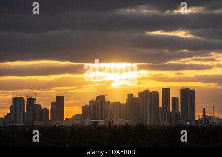 Lebendiges Sonnenlicht durch die Wolken hinter der Skyline von Miami, Florida, von Miami Beach aus gesehen Stockfoto