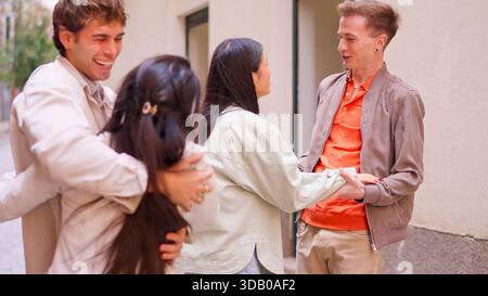 Vielfältige Gruppe junger erwachsener Freunde, die sich im Freien umarmen Stockfoto