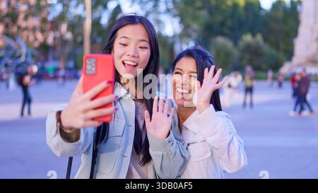 Verschiedene Freundinnen genießen inklusiven Videoanrufe im Freien Stockfoto