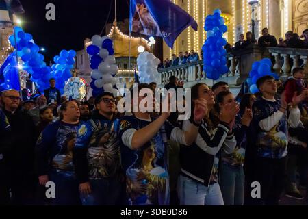 Nachtfestparade mit blauen und weißen Ballons entlang der neonbeleuchteten historischen Straße Stockfoto