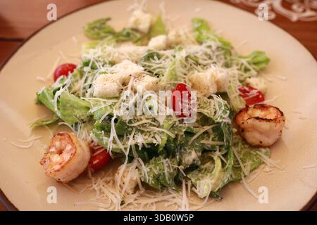 Köstlicher caesar-Salat mit gegrillten Garnelen, frischem Römersalat, Kirschtomaten und Parmesankäse auf einem Teller. Gesundes Essen zum Abendessen. Stockfoto