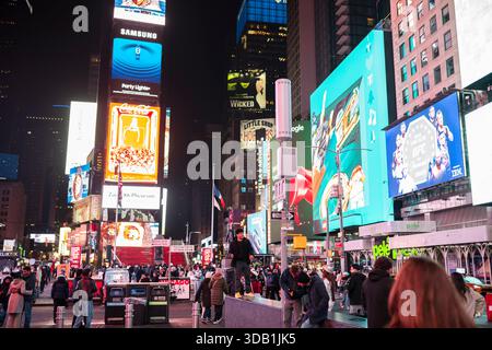 New York City, NY, USA - 10. Dezember 2025: Touristen erkunden den berühmten Times Square im Herzen von Manhattan bei Nacht. Stockfoto