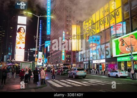 New York City, NY, USA - 10. Dezember 2025: Touristen erkunden den berühmten Times Square im Herzen von Manhattan bei Nacht. Stockfoto