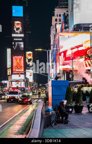 New York City, NY, USA - 10. Dezember 2025: Touristen erkunden den berühmten Times Square im Herzen von Manhattan bei Nacht. Stockfoto