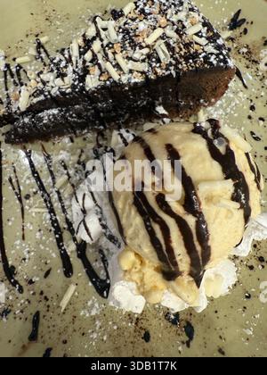 Dekadenter Schokoladenkuchen mit Vanilleeis und Schokoladengläsern auf einem Teller Stockfoto