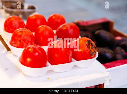 Frische rote Tomaten und Avocados auf dem Marktstand. Stockfoto