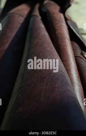 Eindrucksvolle Makrofotografie, die die komplizierte Textur und das Masermuster von hochwertigem braunem Leder aus nächster Nähe erfasst. Das Bild zeigt mehrere Leat Stockfoto