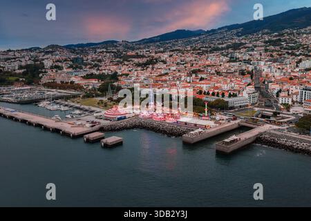 Blick in die Abenddämmerung auf den Hafen von Funchal, das Messegelände und die Stadt am Hügel Stockfoto
