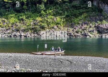 Zwei Männer in Booten auf dem Fluss Kumano während einer Pilgerfahrt in Shingū, Präfektur Wakayama, Japan Stockfoto