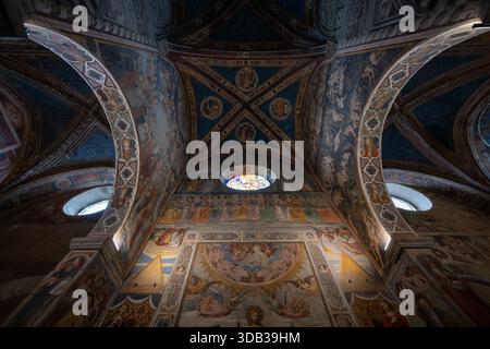 San Gimignano, Italien - 22. Juli 2025: Innenraum des romanischen Duomo di San Gimignano mit mittelalterlichem Freskenzyklus und glasmalerei oculus unter r Stockfoto