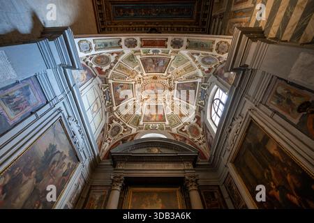 Volterra, Italien - 21. Juli 2025: Blick aus einem tiefen Winkel auf das reich freskierte Renaissancegewölbe und Seitenkapellen in der Kathedrale von Volterra in der Toskana, Italien. Stockfoto