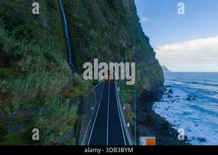 Lufttunnelstraße durch Klippen und Wasserfall an der Nordküste Madeiras Stockfoto