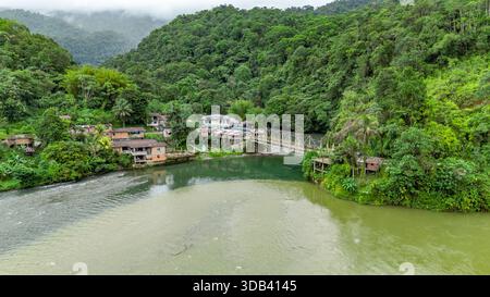 Ein atemberaubender Blick aus der Vogelperspektive auf Agua Clara, Valle del Cauca mit üppigem Grün, einem sich windenden Fluss und malerischen Häusern in der Natur. Stockfoto