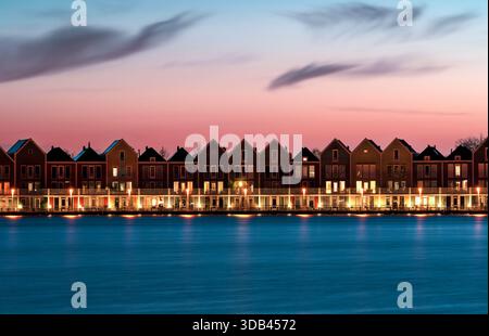 Traditionelle Häuser am Rietplas See bei Sonnenuntergang. Houten, Niederlande Stockfoto