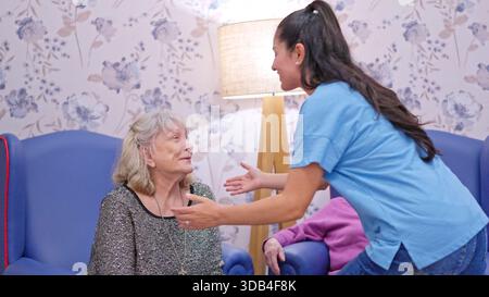 Enkelin im Umgang mit älteren Frauen im Pflegeheim Stockfoto