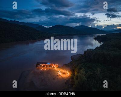 Blick auf die Windlichter und ein Barbecue-Dinner für die Gäste des Boutique-Flusskreuzfahrtschiffes Mekong Sun (Lernidee Erlebnisreisen), das in der Abenddämmerung an einem ankert Stockfoto