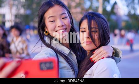Verschiedene Freundinnen machen ein glückliches Selfie im Freien Stockfoto