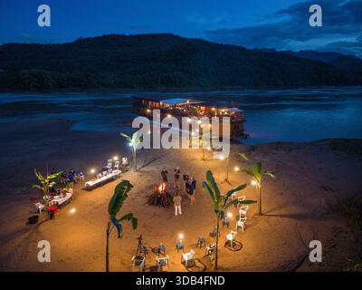 Blick auf die Windlichter und ein Barbecue-Dinner für die Gäste des Boutique-Flusskreuzfahrtschiffes Mekong Sun (Lernidee Erlebnisreisen), das in der Abenddämmerung an einem ankert Stockfoto