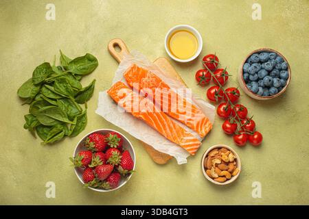 Rohe Lachsfilets, Spinat, Beeren, Kirschtomaten, Mandeln und Olivenöl Stockfoto
