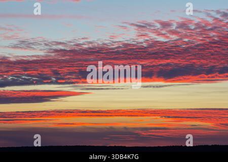 Die Farben fügen sich nahtlos zusammen, während ein beeindruckender Sonnenuntergang leuchtende Farben über den Horizont wirft und eine ruhige Atmosphäre schafft, wenn der Tag in die Nacht übergeht. Stockfoto