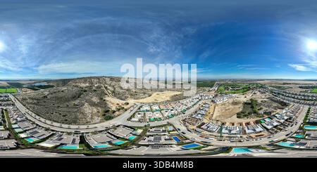 Panoramablick auf die Drohne mit Häusern, Hügeln, Bauarbeiten, Golfplätzen und Ackerland an sonnigen Tagen Stockfoto