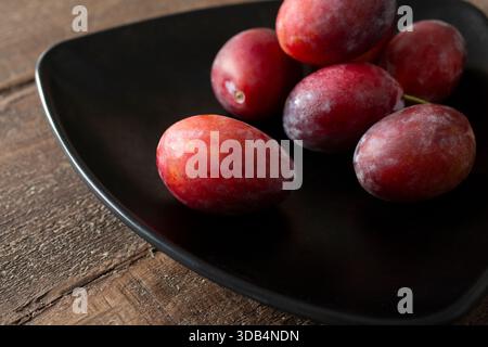 Ein Blick auf einen Teller mit Zuckerpflaumen. Stockfoto