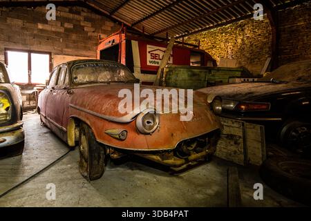 Staubbedeckte Panhard- und Classic-Autos ruhen in einer verlassenen französischen Garage Stockfoto