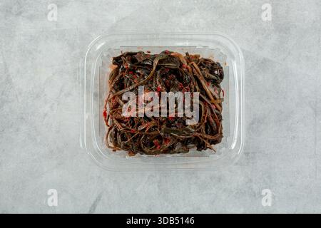 Eine Draufsicht eines Plastikbehälters mit Löwenzahn-Kimchi. Stockfoto