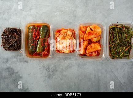 Eine Draufsicht auf eine Vielzahl von Kimchi in Kunststoffbehältern. Stockfoto