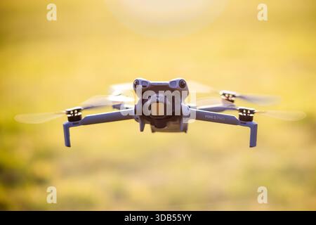Hamburg, Deutschland - 30. September 2025: Eine kleine Konsumdrohne mit Kamera schwebt während des Golden Hour Flugtests in der Luft, Propeller drehen sich mit m Stockfoto