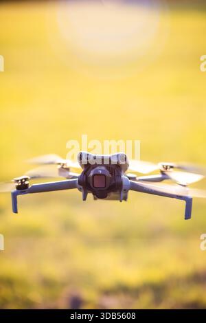 Hamburg, Deutschland - 30. September 2025: Eine kleine Konsumdrohne mit Kamera schwebt während des Golden Hour Flugtests in der Luft, Propeller drehen sich mit m Stockfoto
