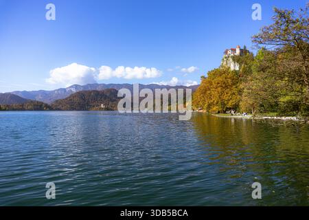 Panoramablick auf den Bleder See mit Schloss mit Blick auf das Wasser und die Kirche auf der Insel im Sonnenlicht, Slowenien Stockfoto