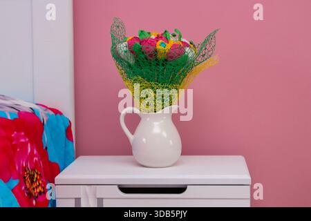 Künstliche Blumen im Schlafzimmer auf dem Nachttisch Stockfoto