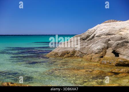 Klares Flachwasser über Felsen entlang der Küste von Mykonos, Kykladen, Griechenland. Stockfoto