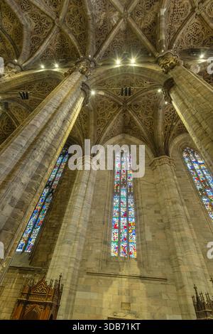Das Innere der gotischen Kathedrale mit hoch aufragenden Steinsäulen, komplizierten Gewölben und farbenfrohen Buntglas. Die dramatische Architektur vermittelt Stockfoto