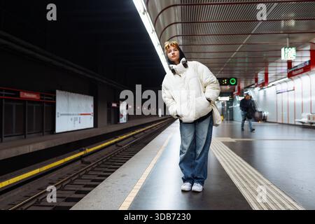 Junge Frau in weißer Winterjacke in der U-Bahn Stockfoto