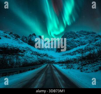 Nordlichter über Landstraßen, schneebedeckte Berge, Sternenhimmel Stockfoto