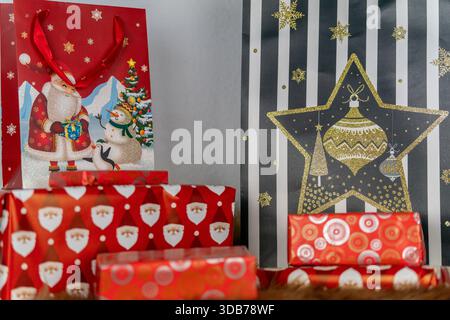 Eine Nahaufnahme einer Auswahl an Weihnachtsgeschenken mit verschiedenen farbenfrohen festlichen Dekorationen Stockfoto