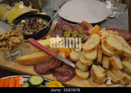 Detaillierte Wurst- und Käseplatte mit gebackenem Brie und Oliven Stockfoto