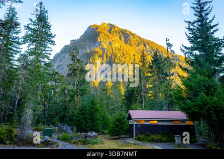 Ein malerischer Blick auf den Mount Rainier ist bei Sonnenaufgang wunderschön beleuchtet, von einem friedlichen Mount Rainier Campingplatz in Washington. Stockfoto